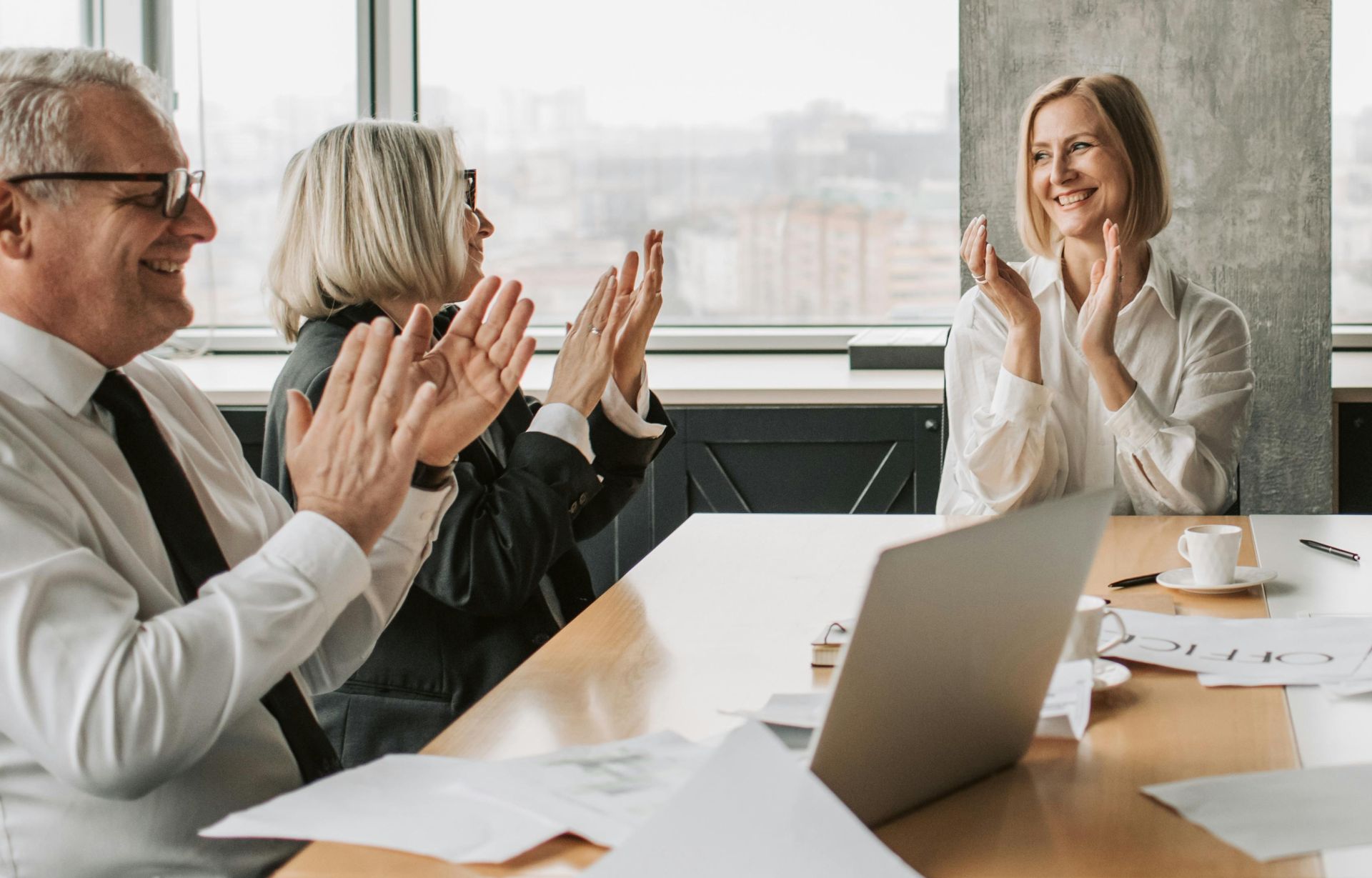 Business professionals clapping in a conference room, creating a lively and positive work environment.